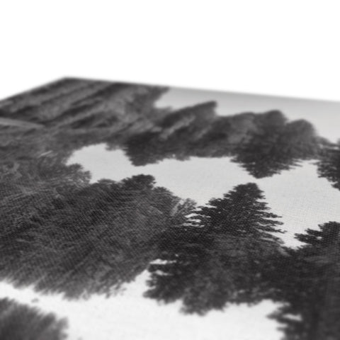 A table covered in printed artwork has pine trees sitting on it.