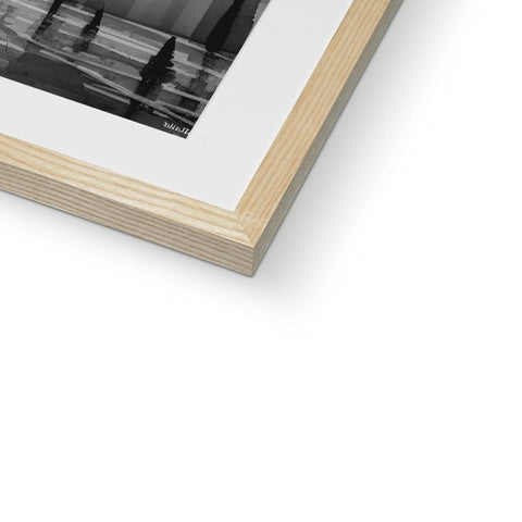 A photo of art print in a white frame by a wood frame.