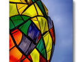 A colorful kite floating over a wood frame under a light light.