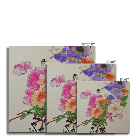 There is a large colorful card on white white wooden wall with several flowers.