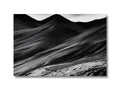 Black and white art print on a backdrop of a mountainous landscape.