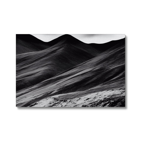 Black and white art print on a backdrop of a mountainous landscape.