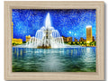 A gold framed art print of a city skyline and a blue building with a silver fountain