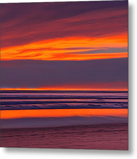 A colorful sunset is reflected in a beach