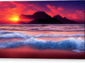 A bright red and orange sunset on blue water with many colorful ocean waves