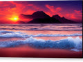 A bright red and orange sunset on blue water with many colorful ocean waves