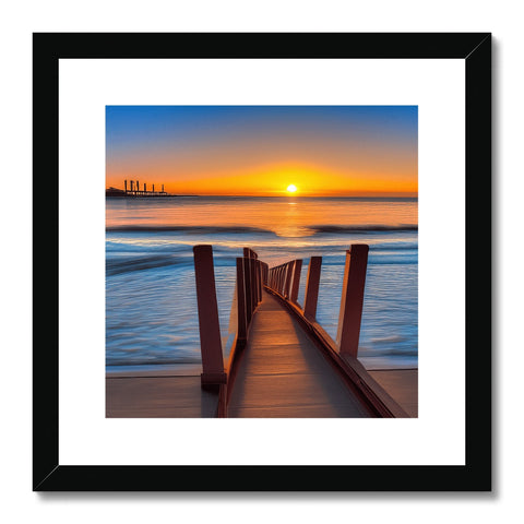 A sunset picture sits on top of a wooden frame with a black border in front of