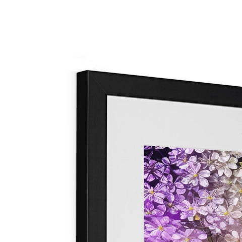 Violet flowers are placed on a frame next to a white picture.