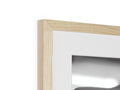 A white photo frame hanging on the wall with a mirror and some pieces of wood in