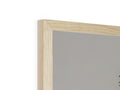 A white wooden picture frame resting on top of a white wall next to a mirror.