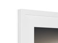 A white picture frame standing in a frame next to a window.