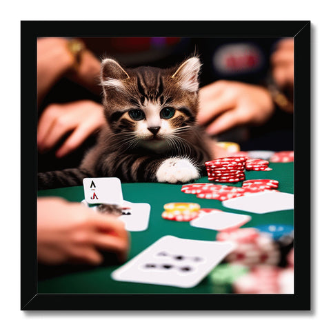 A kitten sitting on the side of a table holding a poker card.