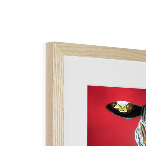 A big white framed picture of a red bird sitting on top of a piece of artwork