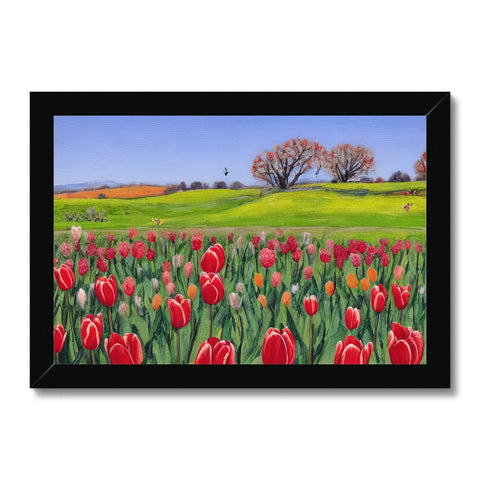 a beautiful framed picture of a field of tulip flowers near a tree