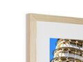 A wooden cage with two pictures sitting on top of it in a blue frame with a