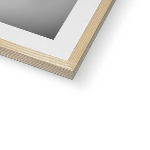 A wooden picture frame sits on a white background in a window frame.