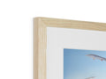 A wooden picture framed by a white picture frame.