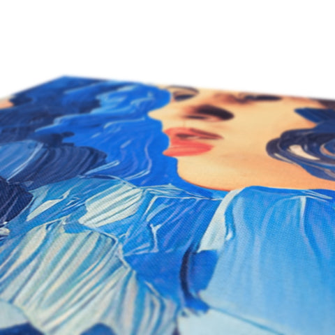 An art print on a table with an electric blue paper backdrop on it.
