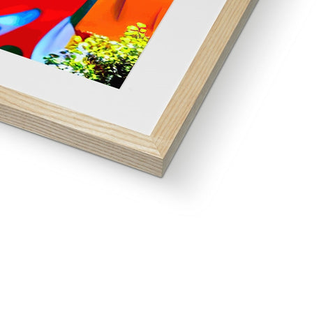 a picture frame filled with a blue art print in wood on top of a green background