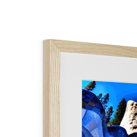 A photo has a wooden picture frame on it in a small place with a tree in