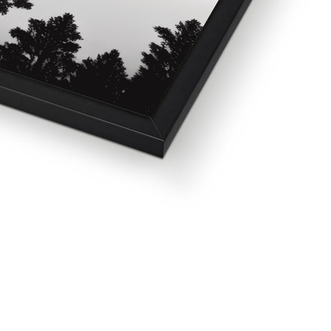 A dark grey picture of a white mirror sitting in a picture frame.