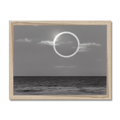 A silver and black framed photograph shows an eclipse happening in the sky and silver.