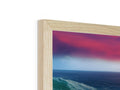 a wooden picture frame with a sunset on the ocean is on top of a glass table