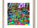 some art of a street lined with colorful umbrellas, large pictures of cats and