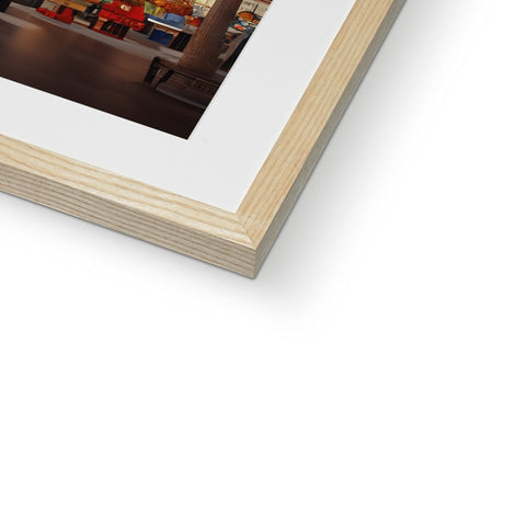 A large wooden picture is framed in a picture frame on a table.