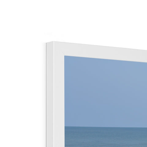 A picture frame with glass with a picture of trees and an ocean.
