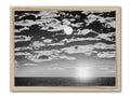 A picture framed image of a sky under a full moon on a wooden background.