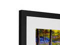 A picture frame is in a black photo frame with colorful art prints on it.