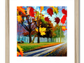 A framed art print with a wooden frame and a tree and fall foliage scene.