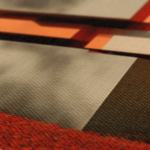 An orange stripe rug covered in textured paper that is brownish in color.
