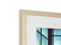 A photograph has a view of a wood picture frame sitting on the wall framed in blue