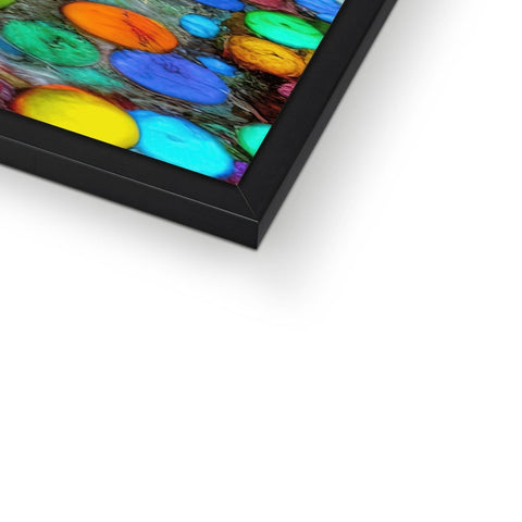 A glass picture frame on top of a table is full of colorful artwork.