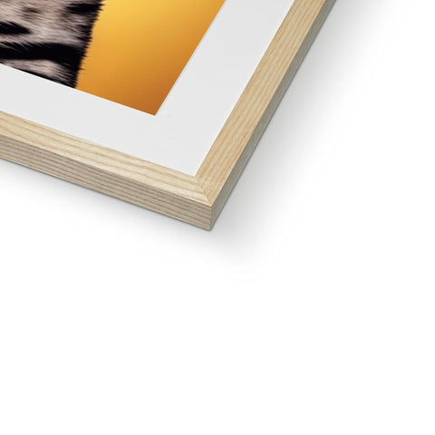 A book holding the animal print photo of a giraffe in a frame on a wall