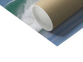 A large paper roll with a toilet pad in the background holding a paper towel.