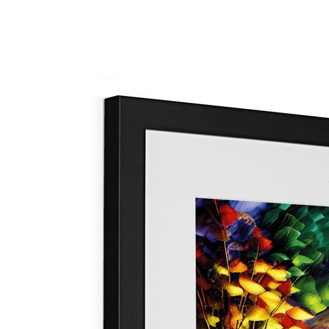 A colorful picture framed in white wall of framed photographs next to a black paper backdrop.