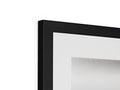 A picture frame with a black and white photo placed under a white backdrop to a glass