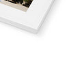 A white photo on a white photo frame next to a stack of other images.