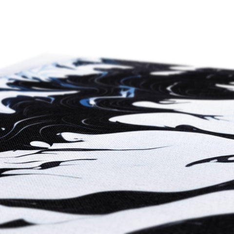 The ocean waves that are breaking up near a black shirt.