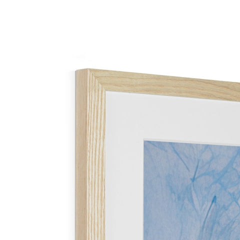A close up of a wooden picture frame with a white picture hung on it.