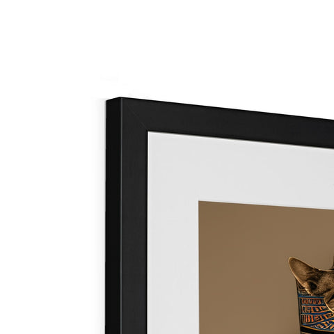 A picture frames with a cat standing under a picture sitting on a wall.