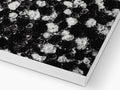 A white paper surface with a black covered rug on top of it.