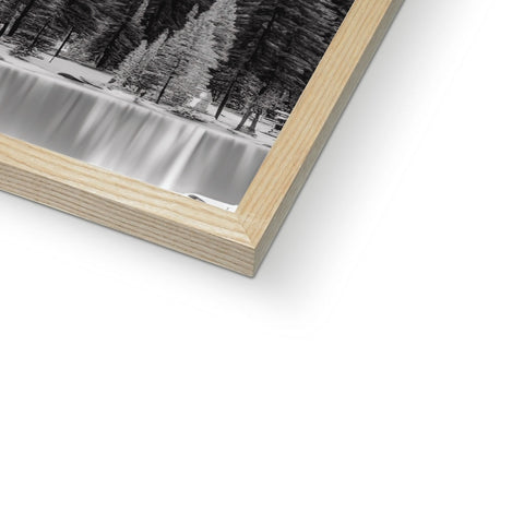 A photograph frames that is holding a picture of a tree near a waterfall.