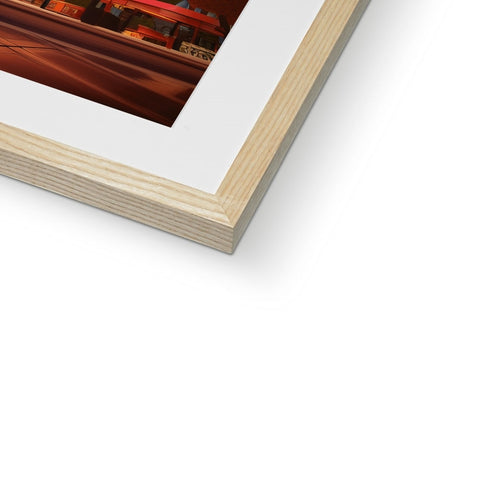 a piece of wood is on top of a picture frame beside a large picture