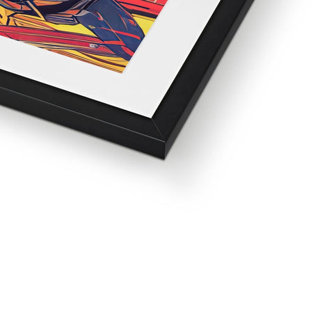 A red and blue framed photo of an art print on a table.