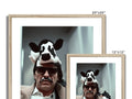 A picture of a stuffed bovine in framed photo with picture frames sitting in a