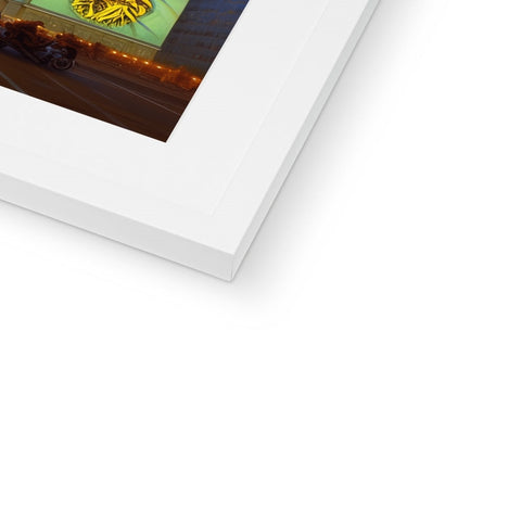 A picture of a picture is framed in a white frame holding a softcover book.